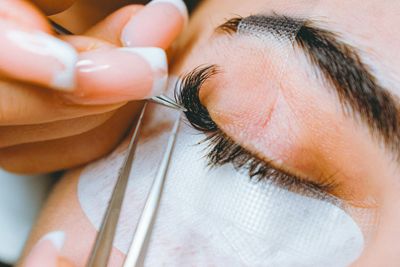 Eyelash technician applying lashes